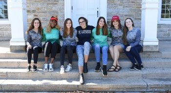 A photo of many St Lawrence students sitting on the stairs of Sykes Hall, each donning a Gretchen Scott clothing item.