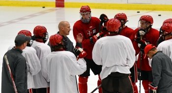 A photo of the hockey team huddled together on the ice.