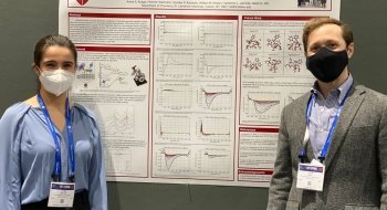 A student and faculty member stand in front of a chemistry research poster at a conference.