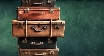 A photo of suitcases stacked on top of one another.