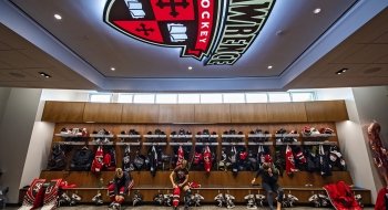 A locker room with the St. Lawrence athletic shield lit up on the ceiling.