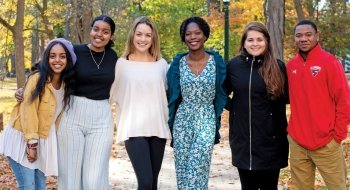 Group of students stand together on campus.