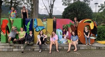 Students posing around Mindo sign