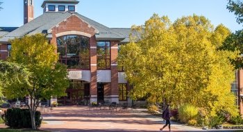 The Sullivan Student Center, a modern brick building, framed by golden trees on a bright fall day on the Saint Lawrence campus.