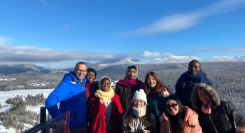 Jeremy Freeman, Class of 1996, director of events at the Olympic Regional Development Authority in Lake Placid, stands with St. Lawrence international students