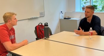 two men sitting at a table having a discussion
