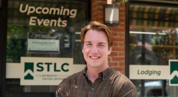 Headshot of Zach Jaworski, standing in front of the St. Lawrence County Chamber of Commerce building.