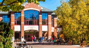 St. Lawrence's Student Center, a modern brick building with multiple levels and large glass windows. Surrounded by yellow foliage on a sunny fall day.