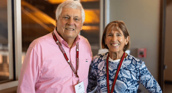 Bill and Jane Christ wearing scarlet and brown lanyards.