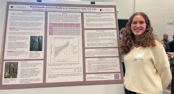 female student smiling presenting her poster