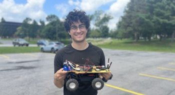 Cai Lemieux Mack '23 holds autonomous rover during his research