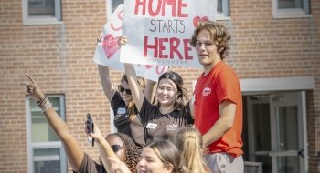 Group of OL cheering, holding &quot;Welcome Home&quot; sign