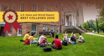 The image shows a group of students sitting on a grassy lawn in front of a red-brick building, engaged in what appears to be a discussion or class session. Overlaid at the top of the image is a banner that reads &quot;U.S. News and World Report Best Colleges 2025&quot; with a red star and ribbon graphic.