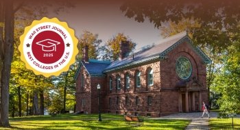 A college campus in autumn with vibrant trees. A historic stone building with arched windows is shown, with a student walking along a path. A badge reads 'Wall Street Journal Best Colleges 2025.'
