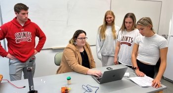 instructor with students standing around