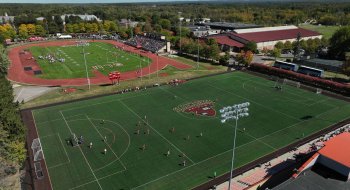Alt text: Aerial view of St. Lawrence University's athletic complex, with soccer and football games taking place simultaneously on adjacent fields during a sunny fall day.