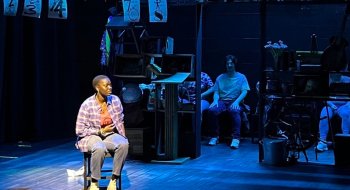 Image of black woman on stage in spotlight