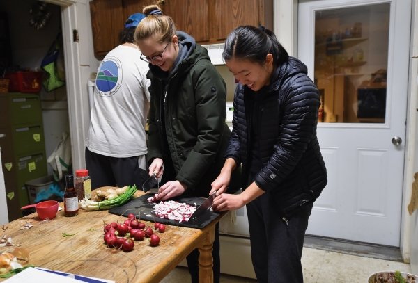A photo of St Lawrence students preparing food at the Greenhouse theme house for a food workshop.