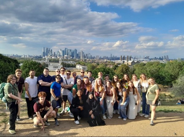 A Group of Students Stands in Front of a City Skyline