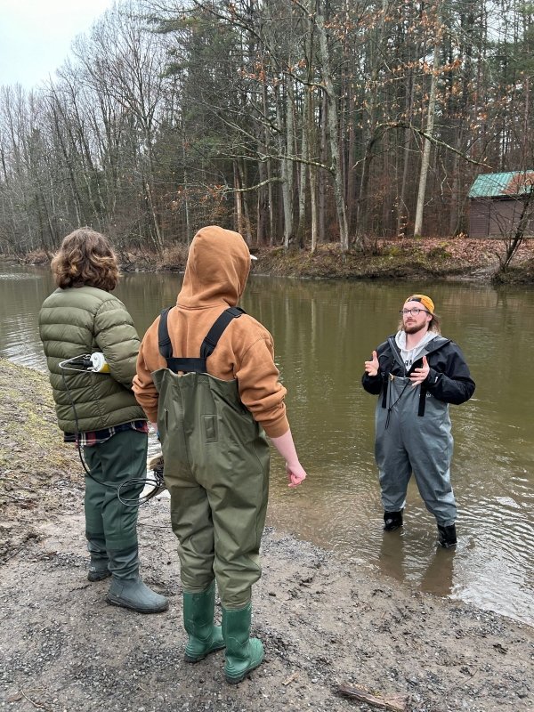 Dan French and two Community Based Learning Students in waders learning about water safety and water monitoring.