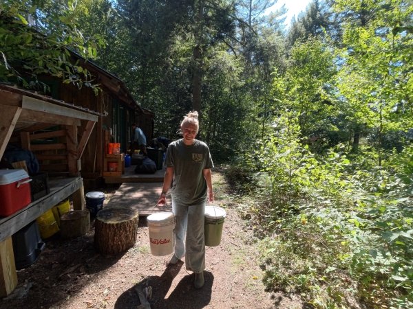 Emily on “pack-out” duty, on her way to dispose of compost.