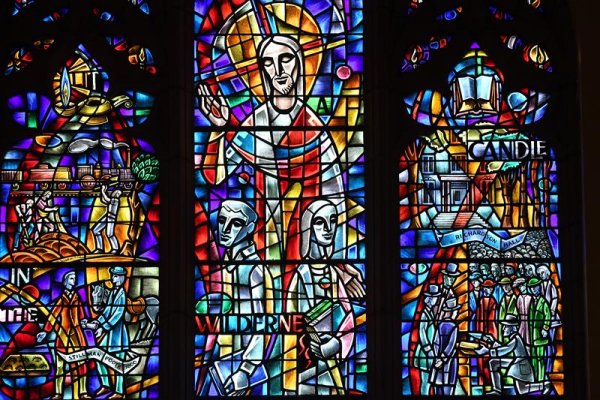 Colorful stained glass windows depicting faith-based figures and scenes.