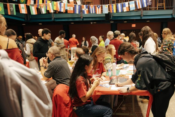 A large group of students crowd around tables to learn about off-campus study