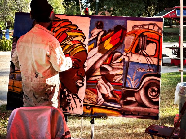 Artists creating a large, colorful mural during an outdoor Arts Collaborative event at St. Lawrence University