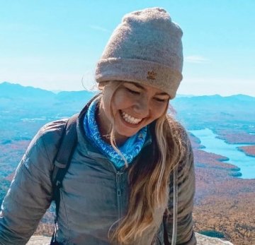Rachel Loyst smiling at the summit of a mountain. 