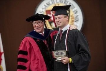President Emeritus Fox poses with Matt Ramm ’20 at Commencement.
