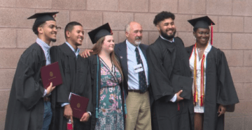 Five members of the Saint Lawrence University class of 2020, wearing graduation regalia, stand with the director of the Saint Lawrence University Higher Education Opportunity Program, Bill Short. 
