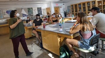 Aswini Pai, a biology professor, teaches a masked biology class attended by several engaged students.