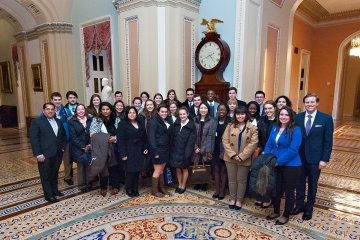 A group of Saint Lawrence University students, wearing business professional attend an alumni event in Washington, D.C. attire, 