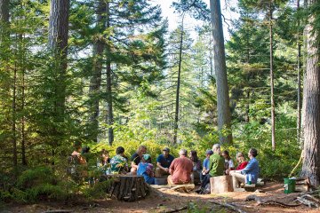 A Saint Lawrence University class meets outside in The Adirondack Park on a sunny day. 