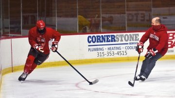 Hockey coach and player skating