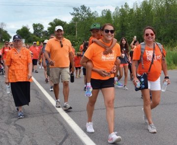 A group of people walking in orange shirts