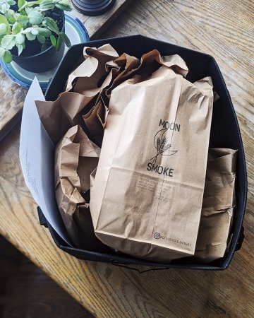 A photo of bread bagged up in a brown paper bag with the logo for Moon Smoke stamped onto it.