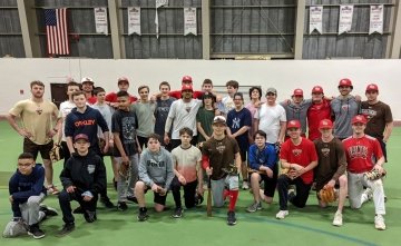 Members of the Saint Lawrence men's baseball team and the Canton modified baseball team gather at an indoor practice field.