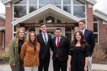 Six members of Saint Lawrence University's student government organization, Thelmo, stnad outside the Diana B. Torrey Health and Counseling Center. 