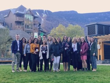 Students gather for a photo at Stowe Ski Resort in Stowe, VT. Mountain and ski lodge in the background.
