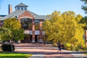 The Sullivan Student Center, a modern brick building, framed by golden trees on a bright fall day on the Saint Lawrence campus.