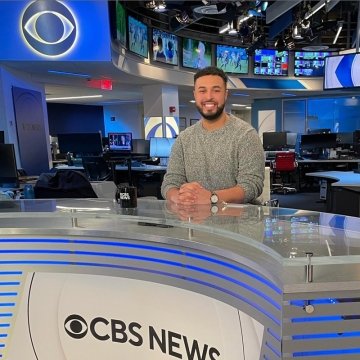 Michael Paulino sitting at the CBS news desk