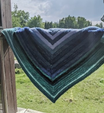 crocheted shawl against pastoral backdrop