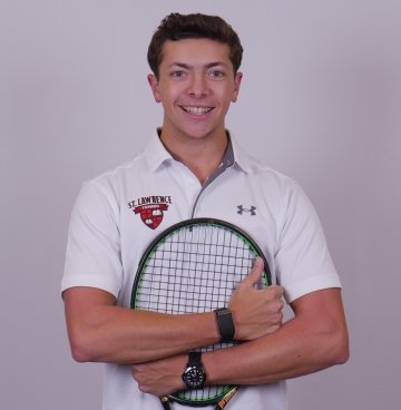 Headshot of Nathan Turtledove, wearing a white collared tennis shirt and holding a tennis racket to his chest.