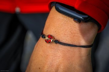 A close up of a small lady bug bracelet on President Morris' wrist.