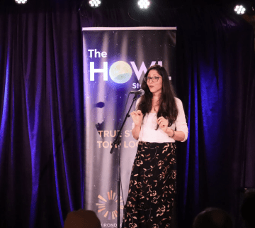 Photo of a contestant (Female) on stage at The Howl Contest speaking into the microphone.