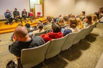 The crowd in Carnegie 10 listening to four former Viebranz Professors of Creative Writing