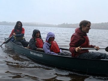 Arcadians laughing as they canoe in the pouring rain. From left: Jordanna, Eva, Marina, Lars.