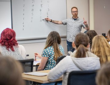 Charles A. Dana Professor of Mathematics Dan Look playing a math-based epidemiology game with visiting students