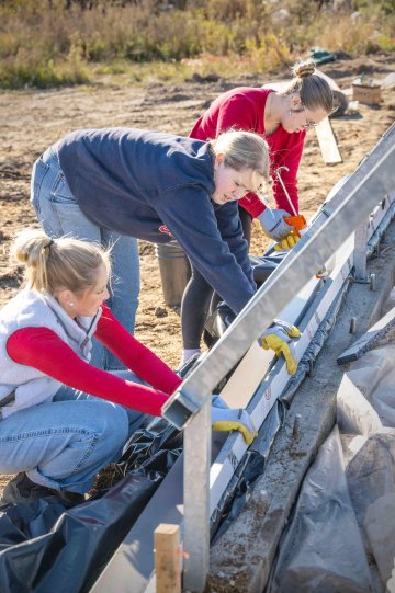 Students helping to build the foundation of the greenhouse